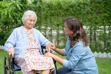 Wall Mural - Caregiver help and care Asian senior woman patient sitting on wheelchair at nursing hospital ward, healthy strong medical.