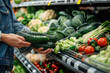 Person choosing fresh vegetables in supermarket
