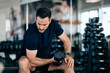 Man trying to be focused on the mind-muscle connection while working out, using a dumbbell, doing an exercise for biceps.