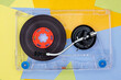 Top view of Turntable arm on old vintage retro audio tape cassettes with a background of multicolored paper sticky notes