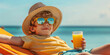 © Oleksandr - Boy in a hat and sunglasses on a sun lounger with a glass of juice on the beach