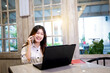 Portrait of businesswoman with laptop talking on the mobile phone to her business colleagues
