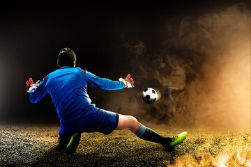 Poster - Portrait of a male goalkeeper trying to stop the ball on the pitch