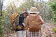 © Natee Meepian - Happy LGBT lesbian couple travel enjoy hiking with backpack in forest trail