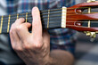 Hands of a young man playing the guitar. Close-up. Selective focus.