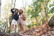 © Natee Meepian - Cheerful romantic lesbian couple traveler with backpack on their backs go hiking through the forest in the mountains in summer
