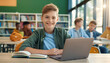 © Janire Fernández - Embracing Learning: Portrait of a Happy Student Boy Positively Posing for the Camera, Seated at His Desk with Laptop and Textbook, Immersed in the Rich Experience of Education and Growth