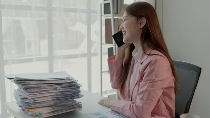 Wall Mural - a lovely employee is talking on the phone with company important client in private office, businesswoman is making a deal with manufactory via a phone, smiling of happiness with company success