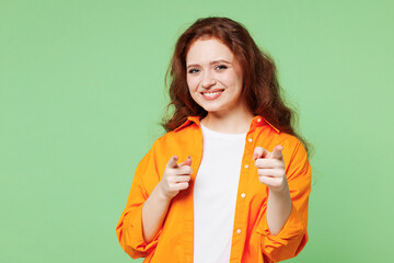 Wall Mural - Young leader confident smiling fun ginger woman she wear orange shirt white t-shirt casual clothes point index finger camera on you isolated on plain pastel light green background. Lifestyle concept.