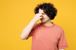 Young frustrated upset sad ill sick man he wear pink t-shirt casual clothes keep eyes closed rub put hand on nose worry isolated on plain yellow orange background studio portrait. Lifestyle concept.