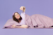 Side view young calm woman wear pyjamas jam sleep eye mask rest relax at home lay down on bed stretch hands wake up isolated on plain pastel light purple background studio Good mood night nap concept