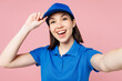 Close up professional delivery girl employee woman wears blue cap t-shirt uniform workwear work as dealer courier do selfie shot on mobile cell phone isolated on plain pink background Service concept