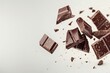 A close up of chocolate pieces flying in the air on white background.
