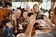 © Davor - Multi generational family posing for a photo in a Christmas decorated cafe