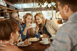 © Davor - Happy young family sitting in cafe decorated for the Christmas holidays