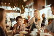 © Davor - Happy young family sitting in cafe decorated for the Christmas holidays