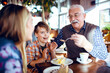 © Davor - Grandfather and grandchildren at a Christmas decorated cafe