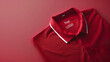 A neatly folded red polo shirt with a white collar and space for a brand logo on a red backdrop