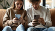 Close up view of man and woman using smartphones discussing mobile apps concept, couple talking holding cellphones synchronizing information online with laptop, checking news or texting messages.