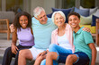 Portrait Of Multi Racial Family With Grandparents And Teenage Grandchildren Sitting On Deck At Home