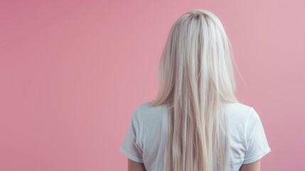 Back portrait of blonde woman wearing a white cropped t-shirt against pink background
