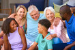 © Monkey Business - Three Generation Family Laughing And Smiling Sitting Outdoors At Home On Deck Together