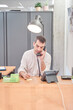 © Oscar - vertical photograph of a man working in the office. he manages appointments via his landline phone.