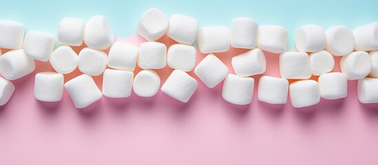 Poster - Marshmallows arranged in a flat lay composition with a copy space frame on a pastel pink and blue background Minimal yet creative concept