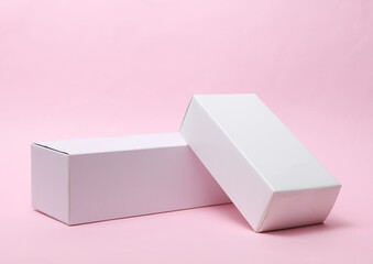 Wall Mural - Different shapes of white cardboard boxes for presentation products on pink background. Mockup for design.