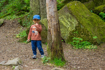 Little boy hiking in the forest on a early spring. Outdoors games for children.