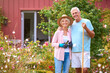 Portrait Of Loving Senior Retired Couple Outdoors At Home Working In Garden Together