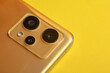 Triple camera of a modern smartphone on a yellow background
