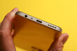 Hand holding smartphone showing inputs on yellow background