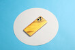 yellow modern smartphone on blue background with white circle