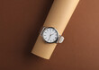 Stylish wristwatch on a brown background. Creative layout