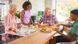 © Monkey Business - Grandparents With Teenage Grandchildren Indoors At Home Eating Breakfast With Parents In Background