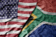 big waving colorful flag of united states of america and national flag of south africa on the dollar money background. finance concept .