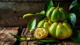 Fresh Garcinia Cambogia Fruit on Green Wooden Background. A Delicious Citrus Dessert with Droplets