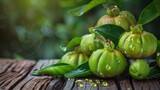 Fresh Garcinia Cambogia Fruit on Green Wooden Background. Health and Freshness Concept