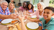 © Monkey Business - Portrait Of Three Generation Family Indoors At Home Doing Cheers With Water Before Eating Meal