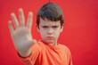 © Ekaterina Pokrovsky - Little boy doing stop gesture with his palm. Closeup of a child showing stop sign with his hand on solid background.