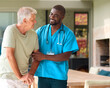 © Monkey Business - Male Nurse Visiting Senior Man Using Walking Stick With Mobility Issues At Home