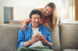 © peopleimages.com - Mature, couple and happy on couch with phone for reading online news, social media scroll and embrace in home. People, hug and laughing with smartphone for funny meme, bingo or digital gaming on sofa