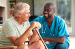 © Monkey Business - Male Nurse Visiting Senior Man Using Walking Stick With Mobility Issues At Home