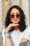 Fototapeta Panele - Stylish beautiful summer girl model with heart-shaped sunglasses in a fashionable white T-shirt in the sunshine