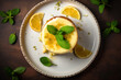 Lemon cake with half lemon slice and peppermint leaf on top on a white plate, top view
