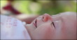 © Marco - Newborn baby infant lying on grass outdoors in dreamy day
