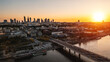 panorama of Warsaw city skyline and Vistula river at sunset, skyscrapers of downtown and green park, aerial top view