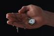 Man holding chain with elegant pocket watch on black background, closeup