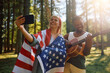 Happy American couple having fun while taking selfie in woods.